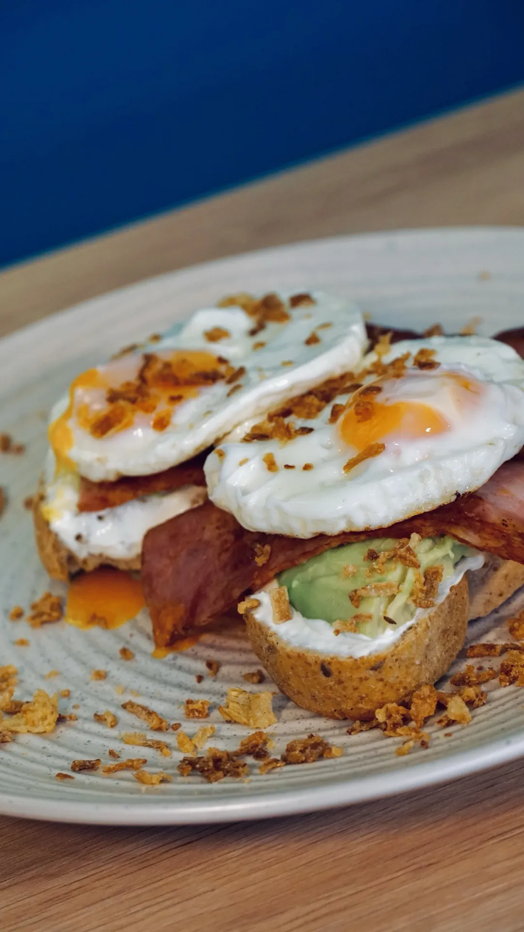 Huevos fritos con tocino y aguacate sobre pan