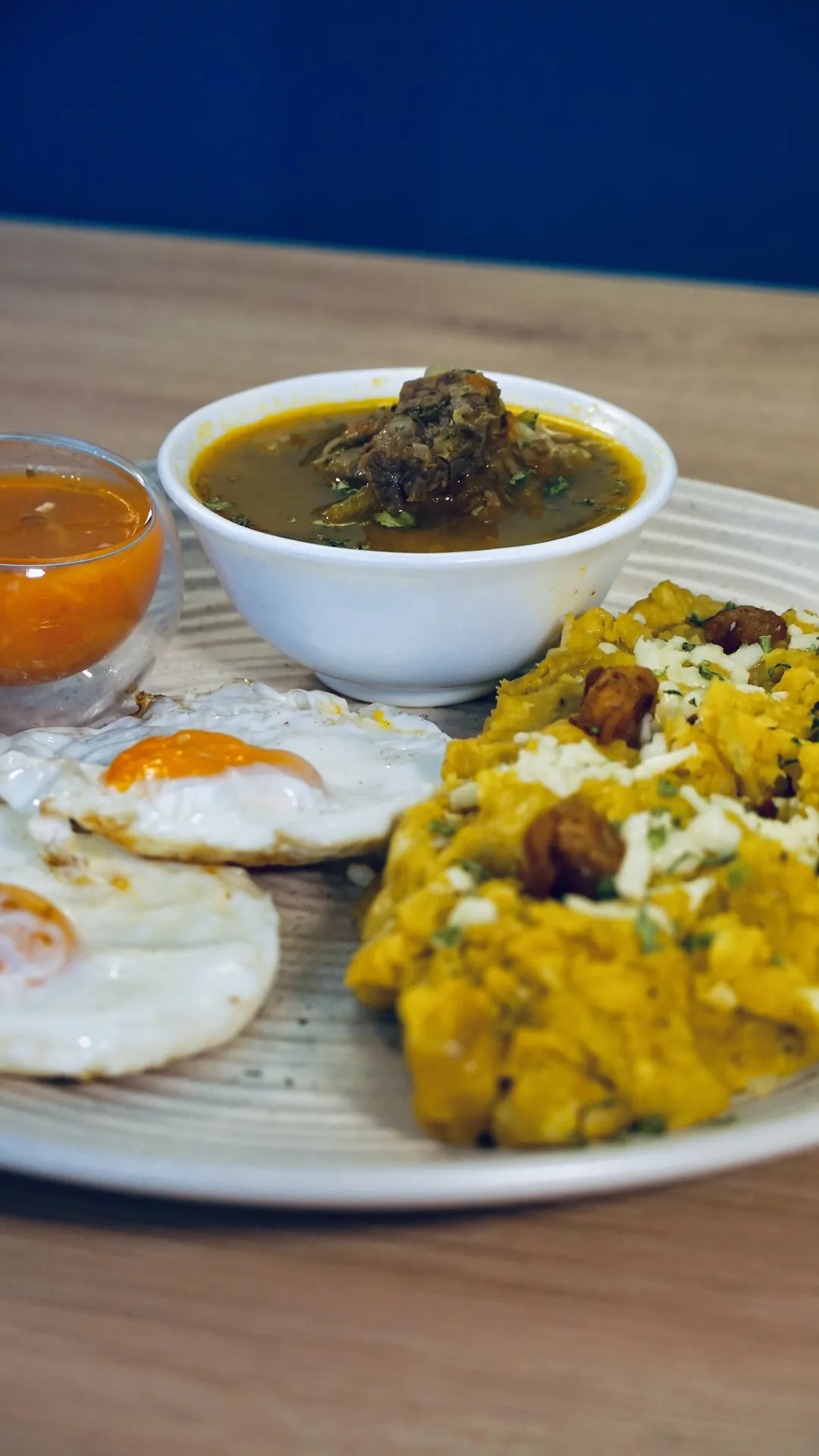 Plato de la casa con huevos fritos, ají y acompañantes