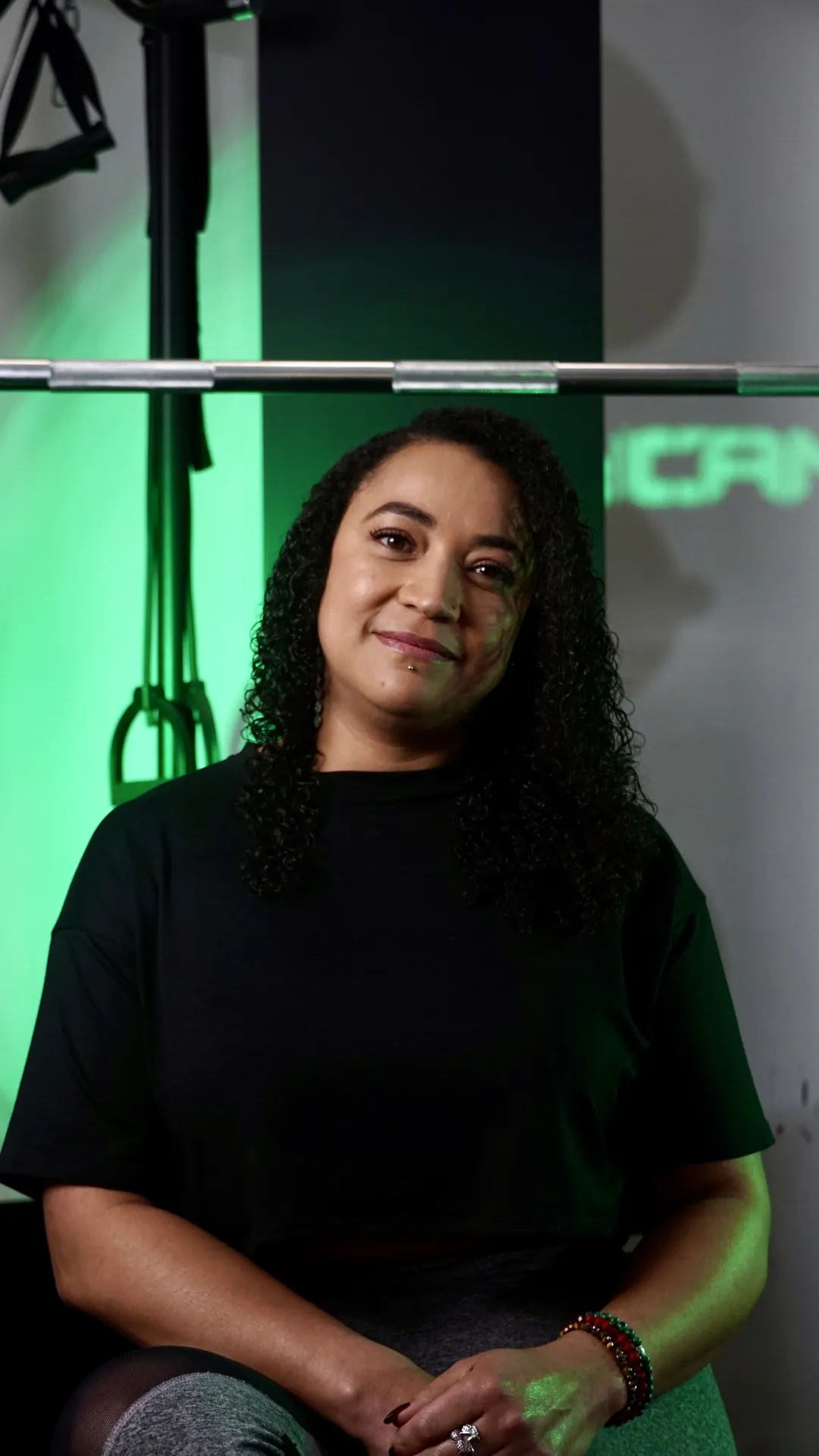 Mujer de camiseta negra sentada en el gimnasio